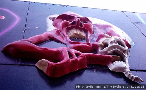 Figures of a skull and a devil in relief on a fairground ride