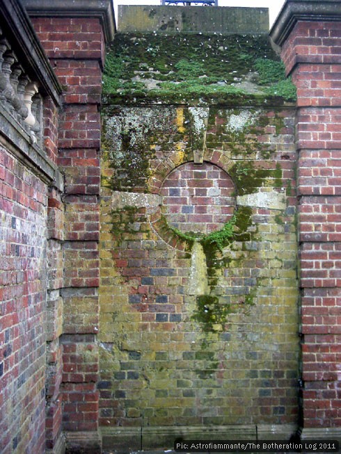 Decorative brickwork under a growth of lichen