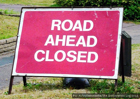 Red sign warning of road closures ahead