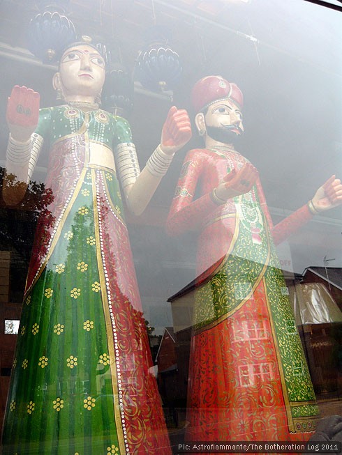 Life-size wooden figures in a shop window