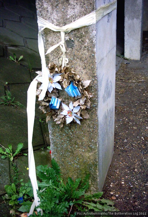 A wreath hanging on the side of a concrete underpass