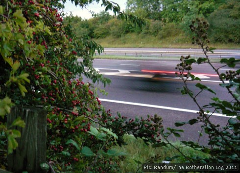 Long-exposure shot of a car racing past on a motorway