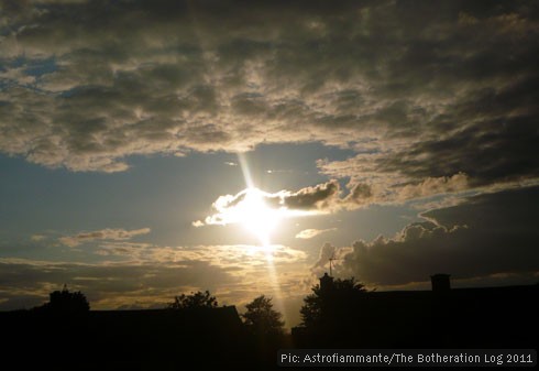 Sun sinking to the horizon in an otherwise cloudy sky