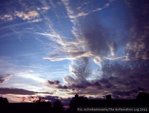 Sunset sky with roofline and contrails