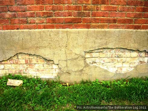 Part of a wall with grass below resembling a tricolour flag design