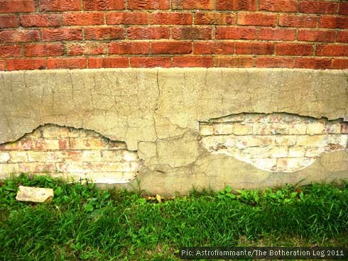 Part of a wall with grass below resembling a tricolour flag design