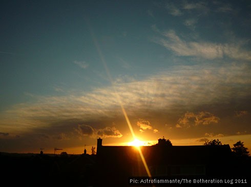 Gold and blue sunset above roofline