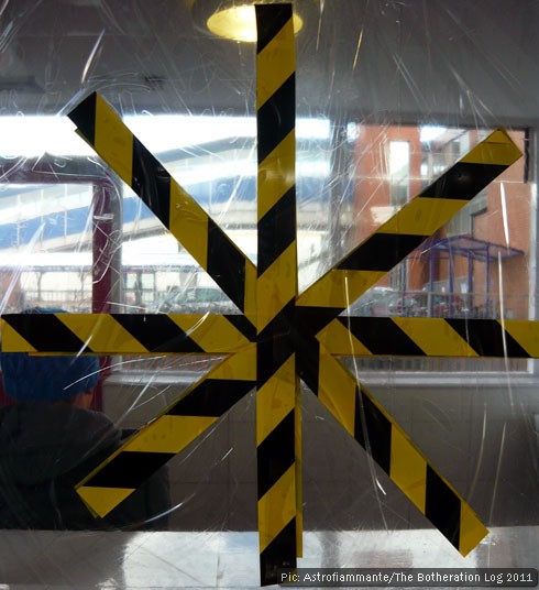 Black and yellow tape on a damaged window pane