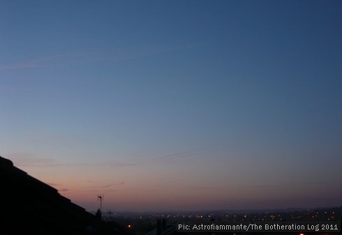 Image of sunrise with pink cloud on the horizon and a still-dark sky above