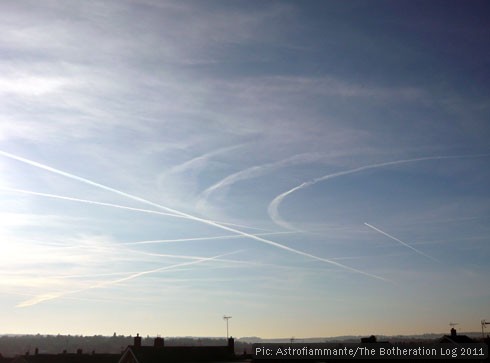 Straight and curving contrails in a blue sky