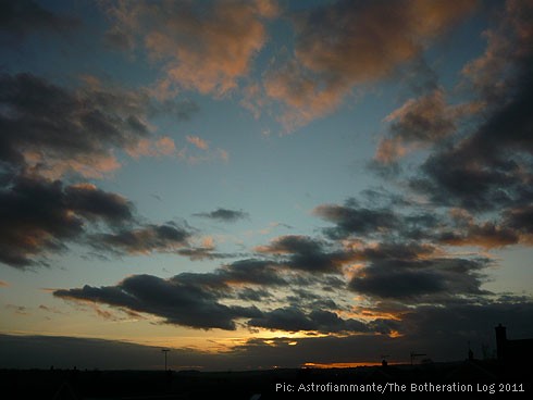 Bronze and dark-grey clouds against light-blue sky