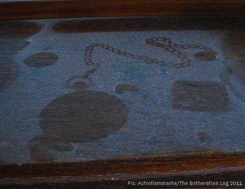 Outline of a pocket watch on an undusted surface