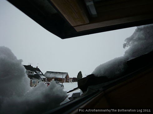 Half-open skylight looking out on heavy snow