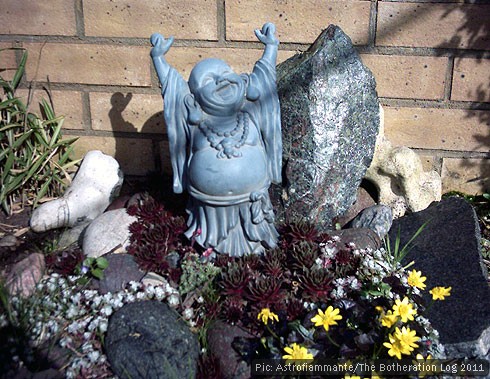 Laughing buddha statue in a sunny garden