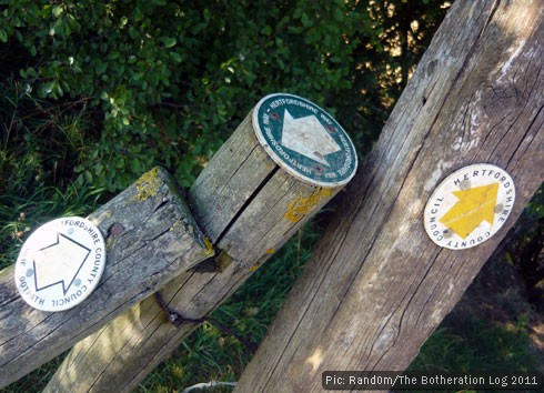 Waymarks on a series of fence posts pointing in different directions