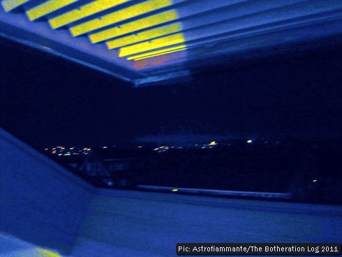 Reverse-colour image of open skylight and blind